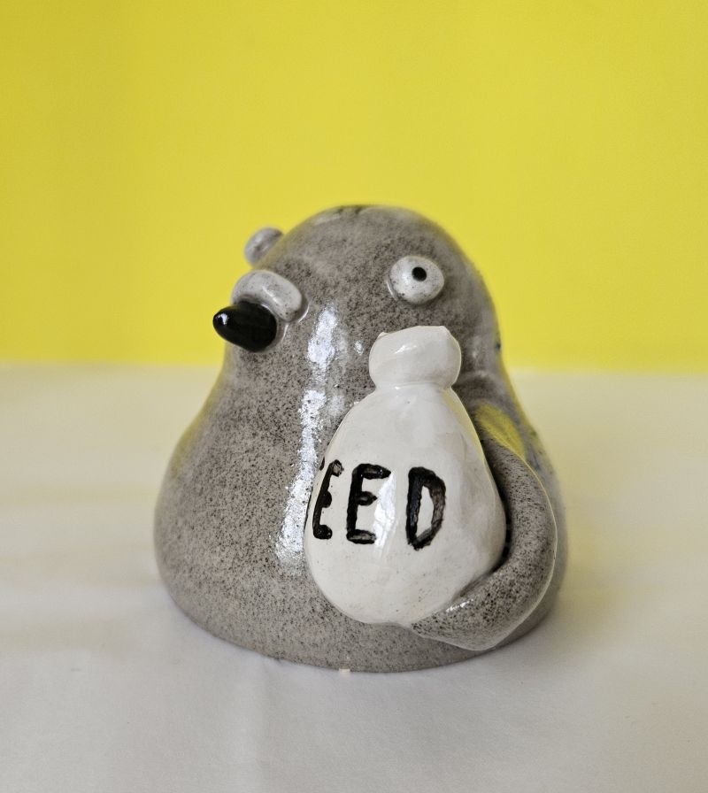 Ceramic pigeon ornament with bag of seed