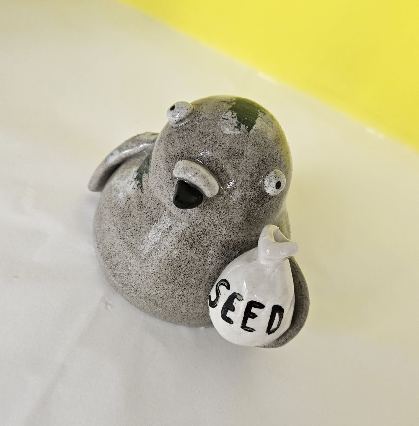 Ceramic pigeon ornament with bag of seed